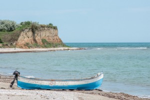 boat on beach with cliffs in the distance